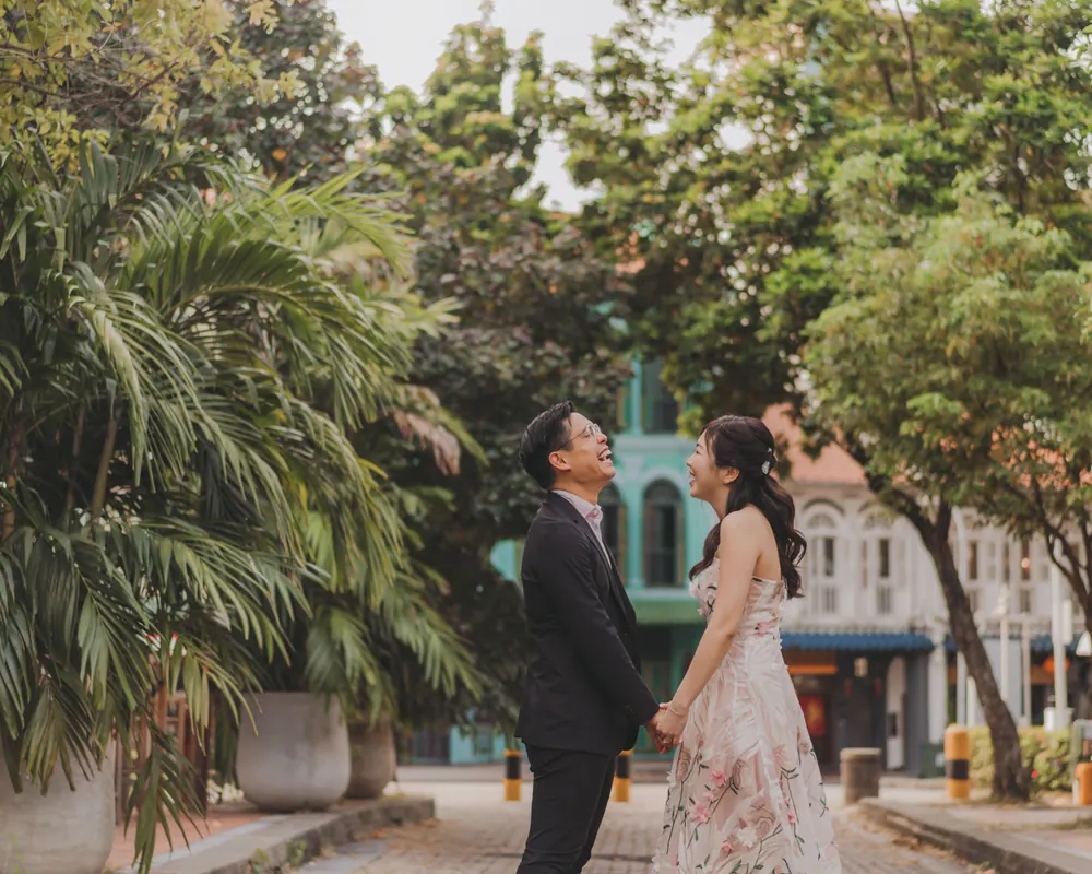 Jingwen and Thai facing each other beneath tropical palms