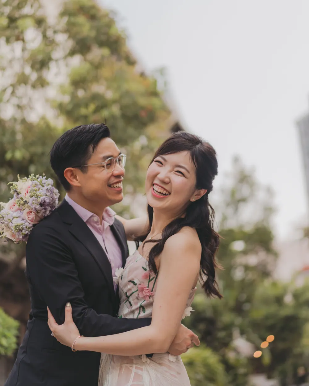 Jingwen and Thai laughing together, arms around each other